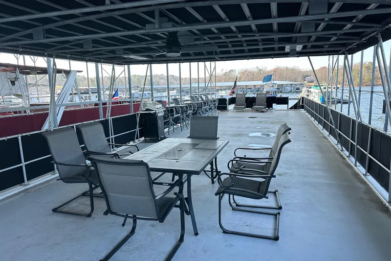 Slide: The Image of Outdoor seating area on a 1999 Sumerset 18x94 houseboat, featuring chairs and a table. - 15