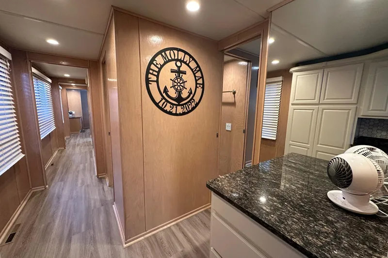 Slide: The Image of Interior of 1999 Sumerset 18x94 houseboat with wood paneling and granite countertop. - 6