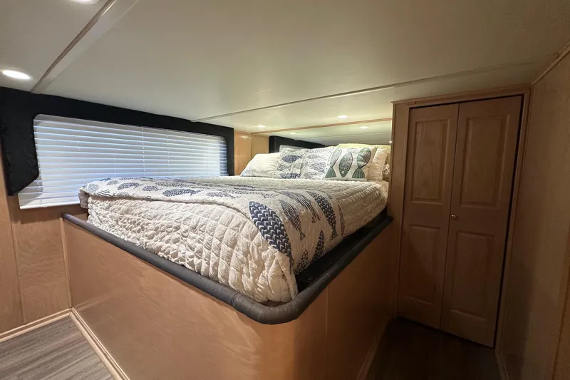 Slide: The Image of Cozy bedroom in 1999 Sumerset 18x94 houseboat with elevated bed and wooden closet. - 7