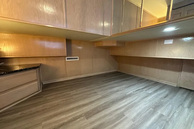 Slide: The Image of Interior of a 1999 Sumerset 18x94 houseboat with wood paneling and laminate flooring. - 8