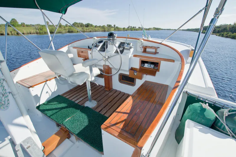 Slide: The Image of 1980 Kadey-Krogen 42 trawler helm with wooden accents, steering wheel, and river view. - 12