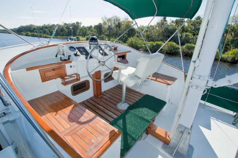 Slide: The Image of Helm of 1980 Kadey-Krogen 42 trawler with wooden accents and green canopy. - 14