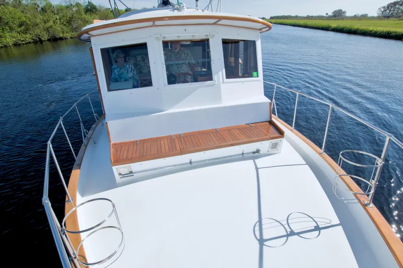 Slide: The Image of 1980 Kadey-Krogen 42 trawler navigating a serene waterway, showcasing its classic design. - 25