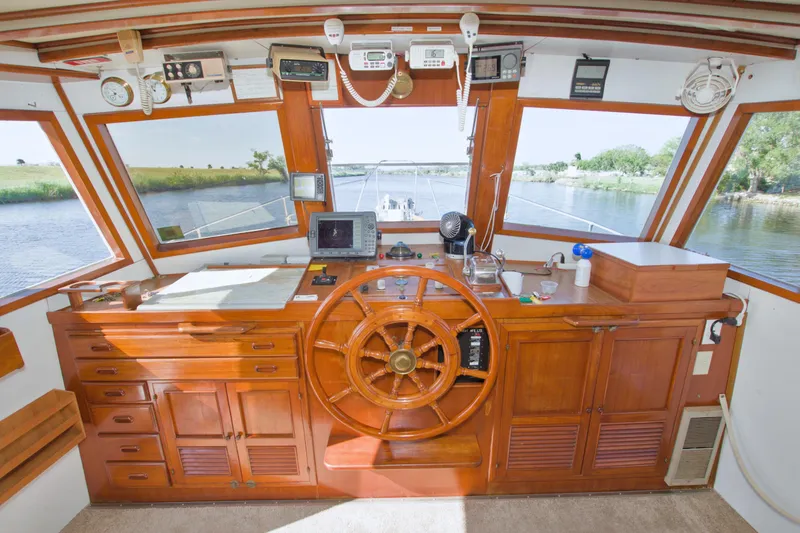 Slide: The Image of 1980 Kadey-Krogen 42 trawler helm with wooden wheel and navigation equipment. - 32
