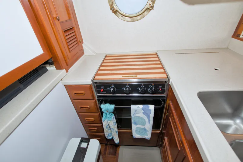 Slide: The Image of 1980 Kadey-Krogen 42 trawler kitchen with stove, wooden cabinets, and countertop. - 44