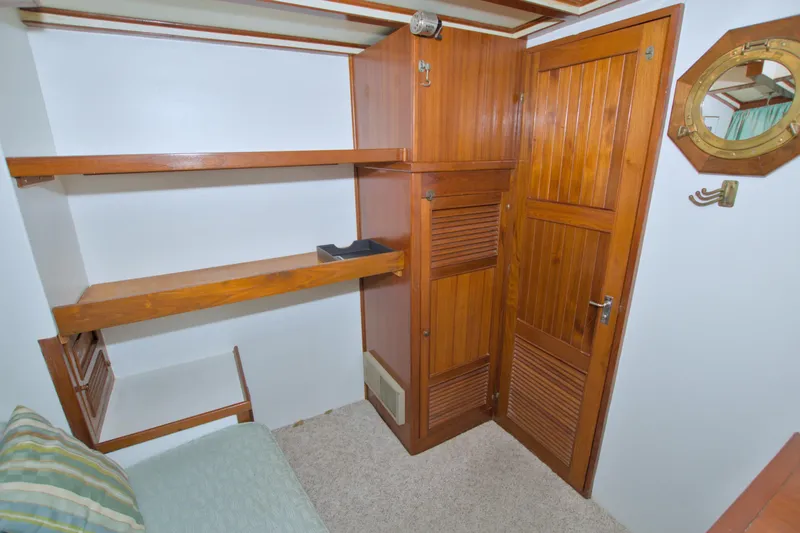 Slide: The Image of 1980 Kadey-Krogen 42 trawler interior with wooden shelves and door, nautical decor. - 59