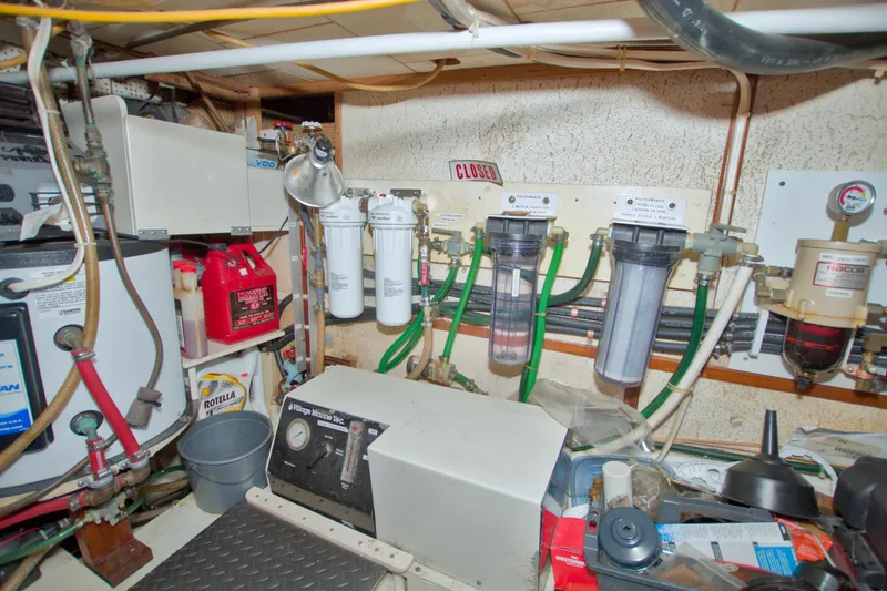 Slide: The Image of Engine room of a 1980 Kadey-Krogen 42 trawler with various equipment and filters. - 79