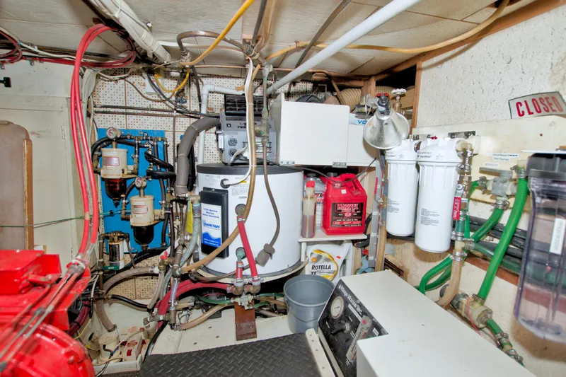 Slide: The Image of Engine room of a 1980 Kadey-Krogen 42 trawler with various equipment and piping. - 80