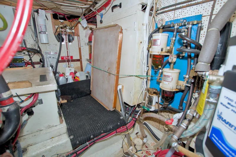 Slide: The Image of Engine room of a 1980 Kadey-Krogen 42 trawler with various equipment and wiring. - 82