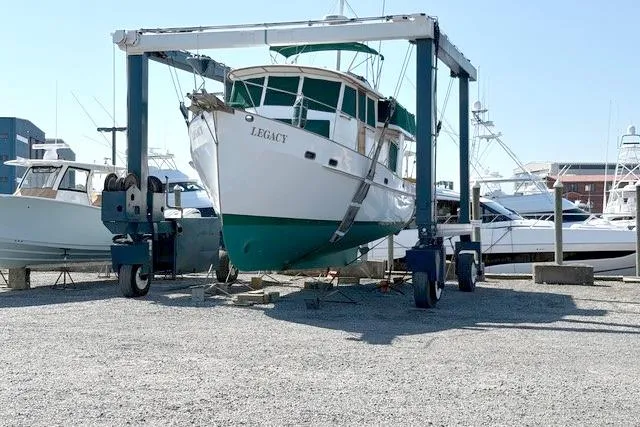 Slide: The Image of 1980 Kadey-Krogen 42 trawler "Legacy" in dry dock, surrounded by other boats. - 86