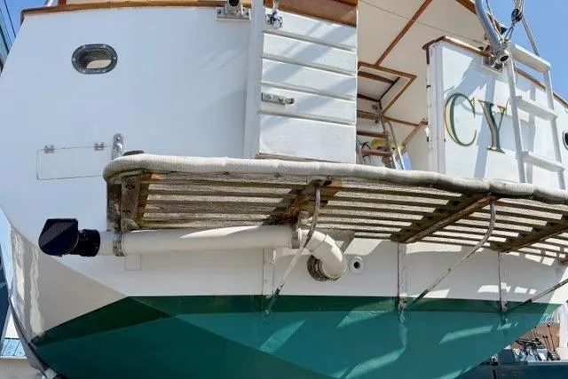 Slide: The Image of 1980 Kadey-Krogen 42 trawler stern view with green hull and deck details. - 93
