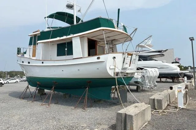 Slide: The Image of 1980 Kadey-Krogen 42 trawler on dry dock, green and white exterior. - 95