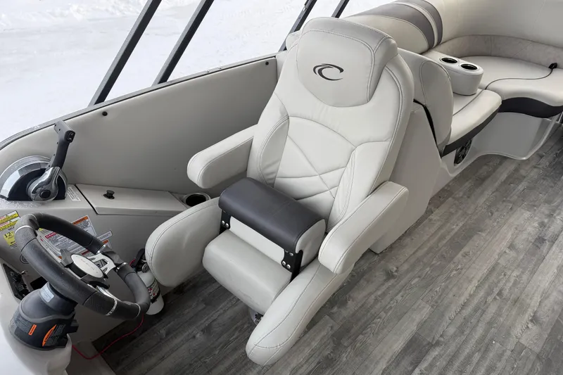 Slide: The Image of 2019 Crest Classic 230 SLC boat interior with steering wheel and plush seating. - 14