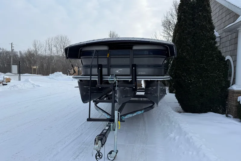 Slide: The Image of 2019 Crest Classic 230 SLC pontoon boat on snowy driveway, front view. - 2