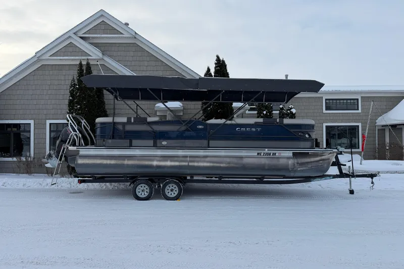 Slide: The Image of 2019 Crest Classic 230 SLC pontoon boat on trailer, parked in snowy setting. - 3