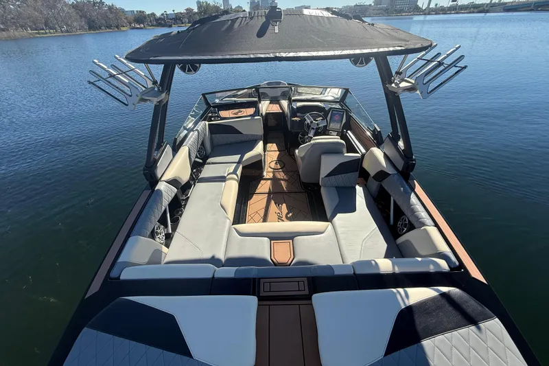 Slide: The Image of 2022 Tigé Z1 boat interior with spacious seating and modern design on a calm lake. - 2