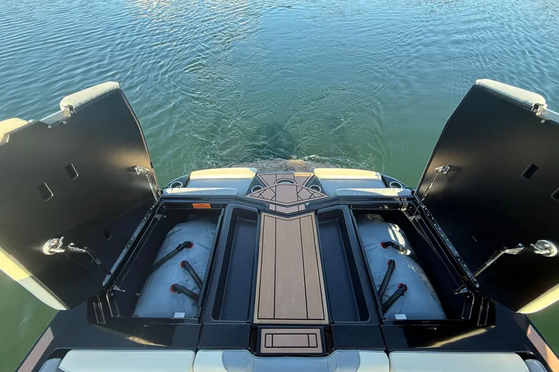 Slide: The Image of 2022 Tigé Z1 boat with open storage compartments on calm water. - 6