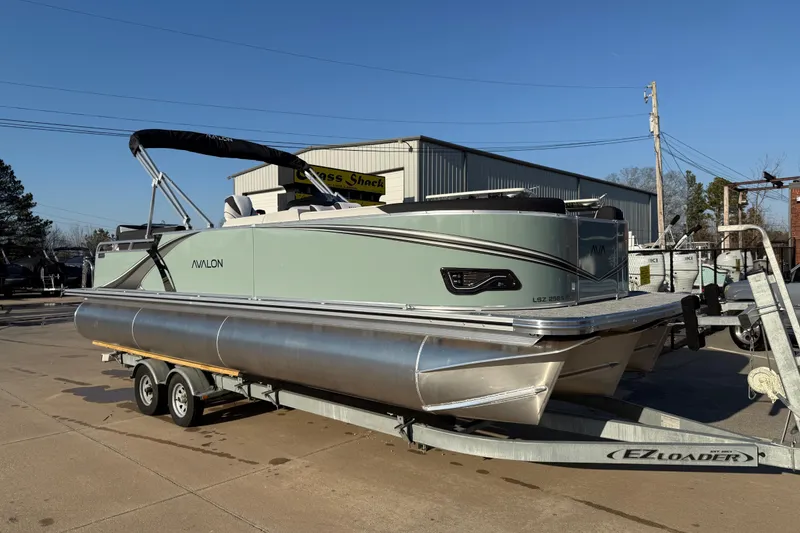The Image of 2026 Avalon LSZ Quad Lounger Shift pontoon boat on trailer, sunny day. - 0