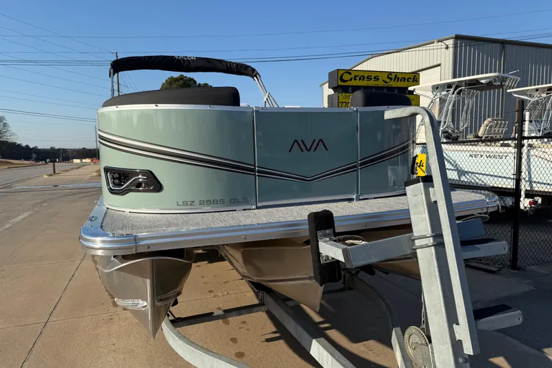 Slide: The Image of 2026 Avalon LSZ QUAD LOUNGER SHIFT pontoon boat on trailer at dealership. - 2