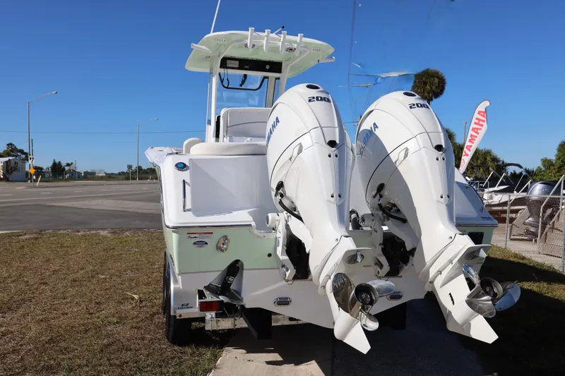 Slide: The Image of 2026 Sea Hunt Ultra 275 SE boat with dual Yamaha 200 engines, parked outdoors. - 17