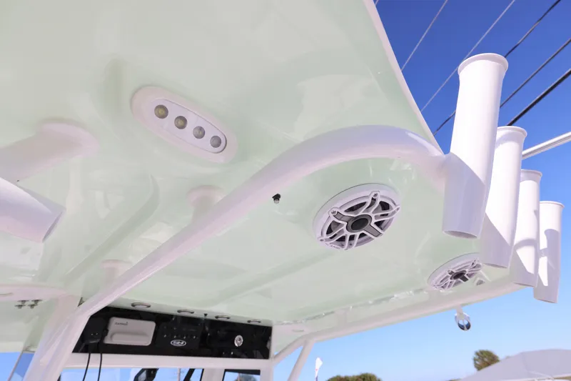 Slide: The Image of 2026 Sea Hunt Ultra 275 SE boat roof with rod holders and speakers against blue sky. - 27