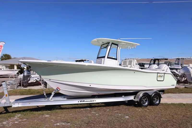 Slide: The Image of 2026 Sea Hunt Ultra 275 SE boat on trailer, displayed outdoors under clear blue sky. - 31