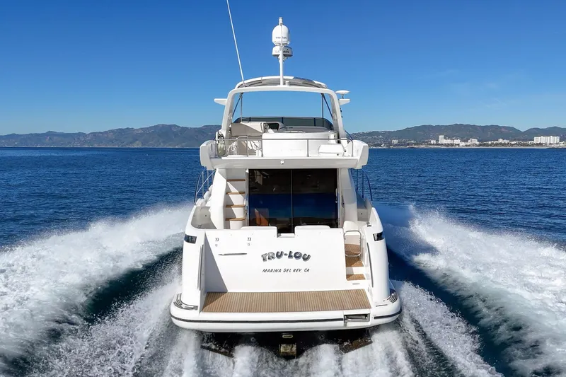 Slide: The Image of Azimut 58 yacht cruising on open water, 2002 model, scenic coastal backdrop. - 24