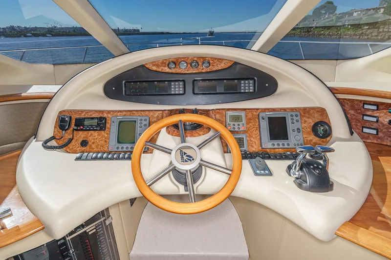 Slide: The Image of Cockpit of a 2002 Azimut 58 yacht with advanced navigation controls and wooden steering wheel. - 37
