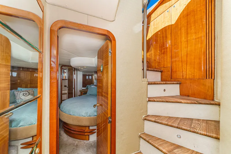 Slide: The Image of Interior of 2002 Azimut 58 yacht, featuring wooden stairs and a cozy bedroom. - 39