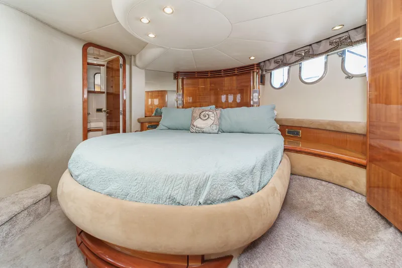 Slide: The Image of Luxurious 2002 Azimut 58 yacht bedroom with round bed and elegant wood accents. - 40