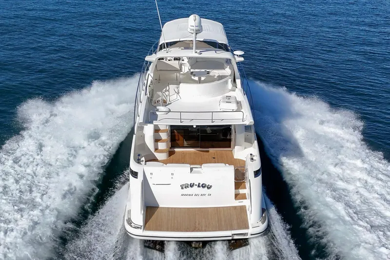 Slide: The Image of 2002 Azimut 58 yacht cruising on open water, rear view. - 5