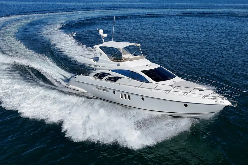 Slide: The Image of Luxurious 2002 Azimut 58 yacht cruising on open water, creating a dynamic wake. - 7
