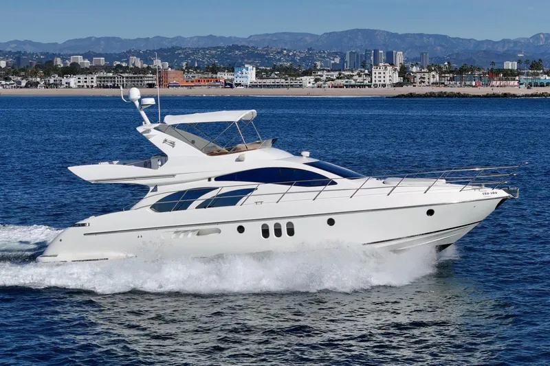 Slide: The Image of Luxury 2002 Azimut 58 yacht cruising on blue ocean near city skyline. - 8