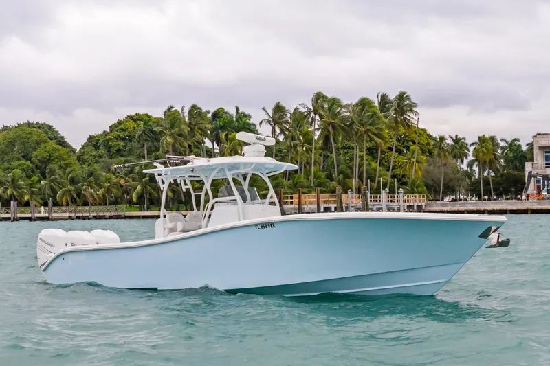 The Image of 2021 Yellowfin 36 Offshore boat cruising near palm-lined shore. - 1