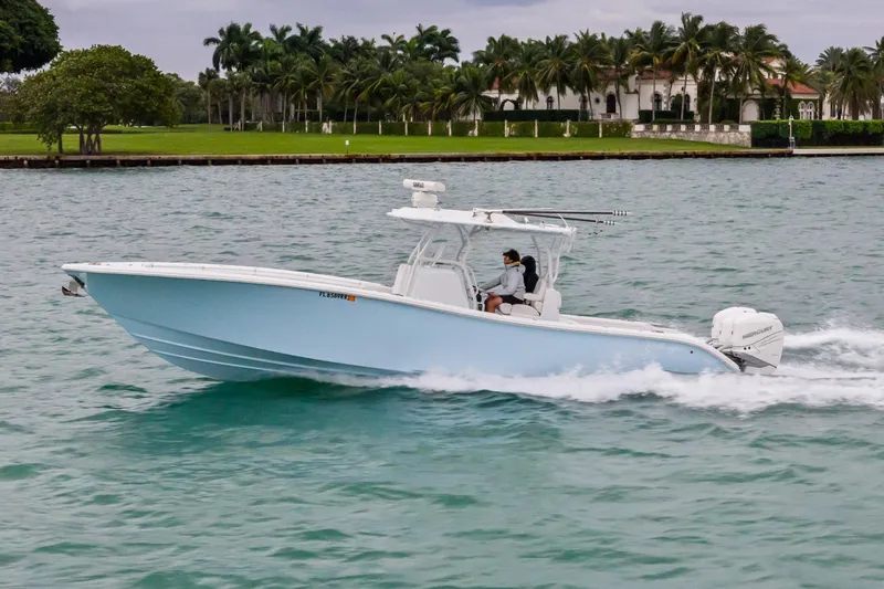 Slide: The Image of 2021 Yellowfin 36 Offshore boat cruising on water near palm trees. - 13