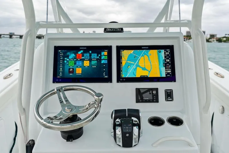 Slide: The Image of 2021 Yellowfin 36 Offshore boat dashboard with dual Simrad displays and steering wheel. - 25