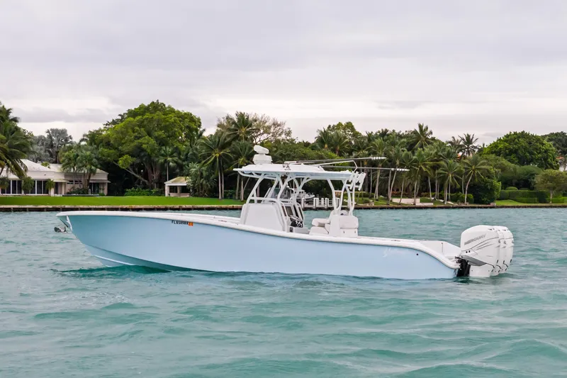 Slide: The Image of 2021 Yellowfin 36 Offshore boat on turquoise water, surrounded by lush greenery. - 6