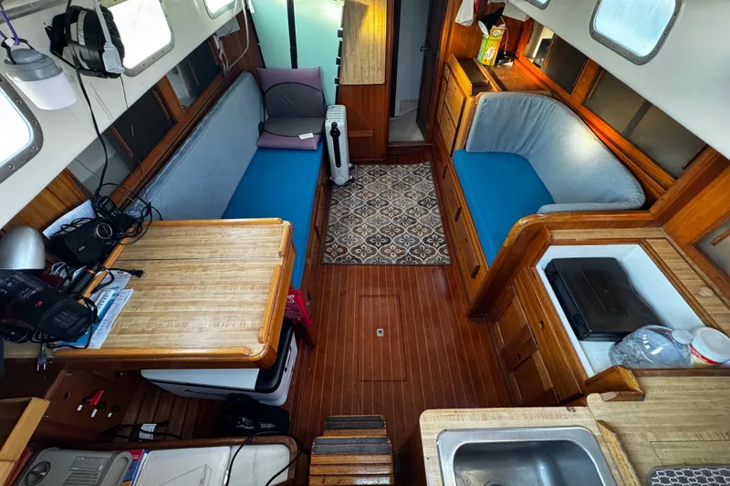Slide: The Image of Interior of a 1977 Bristol 29.9 sailboat with wooden furnishings and blue seating. - 45
