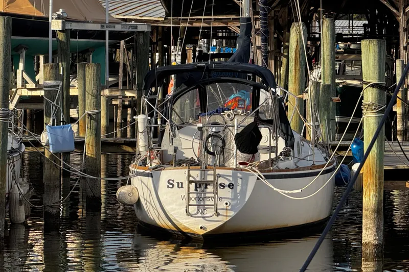 Slide: The Image of 1977 Bristol 29.9 sailboat docked at marina, surrounded by wooden posts. - 5