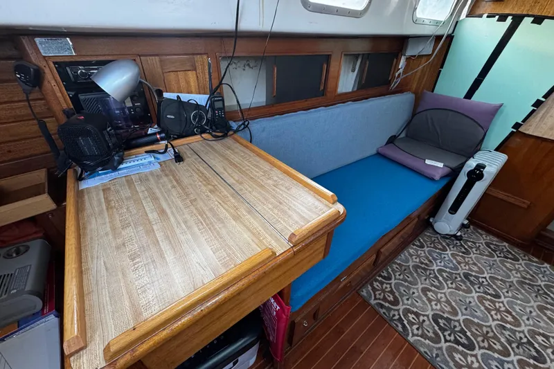 Slide: The Image of 1977 Bristol 29.9 yacht interior with wooden desk, blue seating, and nautical equipment. - 52