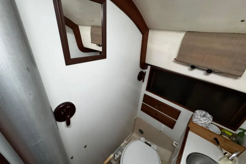 Slide: The Image of 1977 Bristol 29.9 yacht bathroom interior with mirror, sink, and storage cabinets. - 55