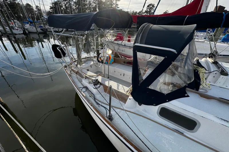 Slide: The Image of 1977 Bristol 29.9 sailboat docked at marina, featuring a covered cockpit and sleek design. - 8