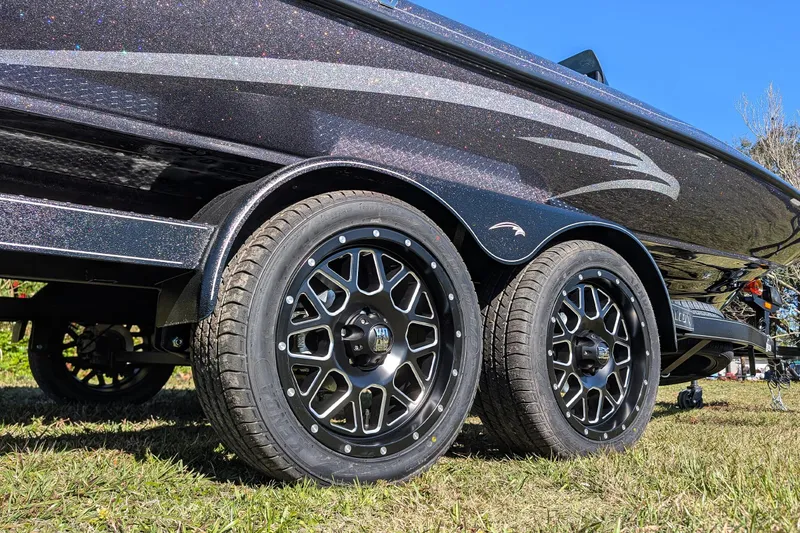 Slide: The Image of Trailer wheels of 2026 Falcon F20 PREDATOR boat on grass, showcasing sleek design. - 13