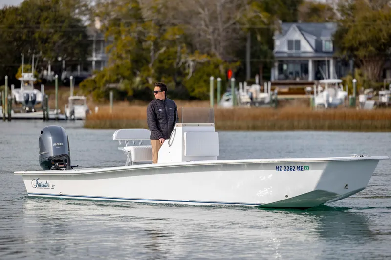 The Image of 2025 Intruder 23 boat on water with person standing, scenic background. - 0