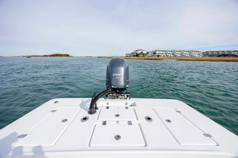 Slide: The Image of 2025 Intruder 23 boat on water with 200 HP engine, coastal view. - 13