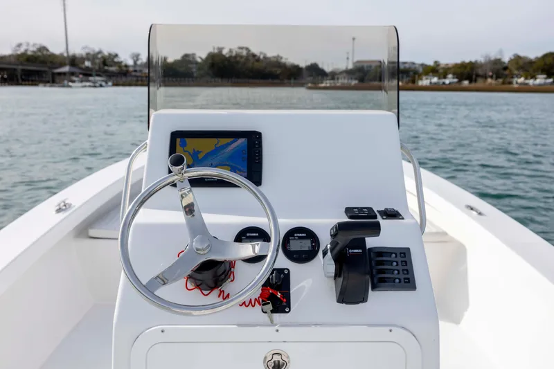 Slide: The Image of 2025 Intruder 23 boat dashboard with steering wheel and navigation system on water. - 16