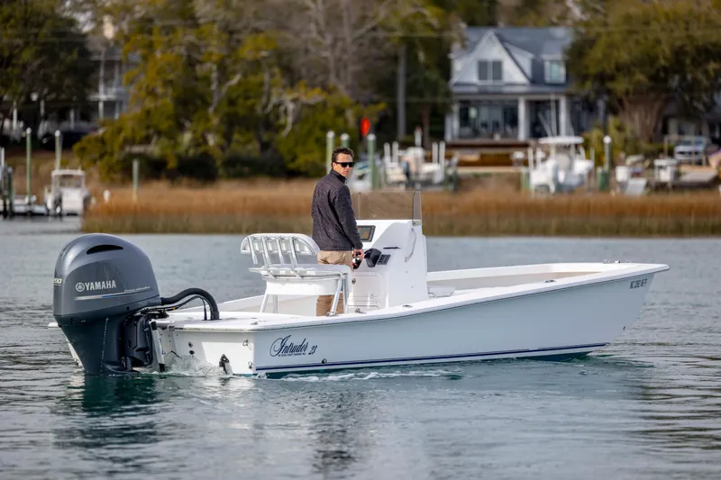 Slide: The Image of 2025 Intruder 23 boat with Yamaha engine on calm water near docks. - 2