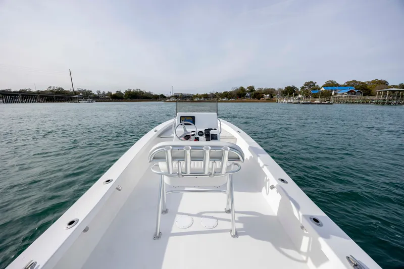 Slide: The Image of 2025 Intruder 23 boat on calm water, showcasing sleek design and open deck. - 23