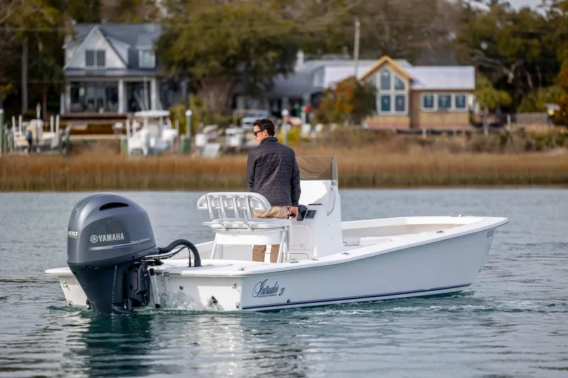 Slide: The Image of 2025 Intruder 23 boat with Yamaha engine on calm water near houses. - 3