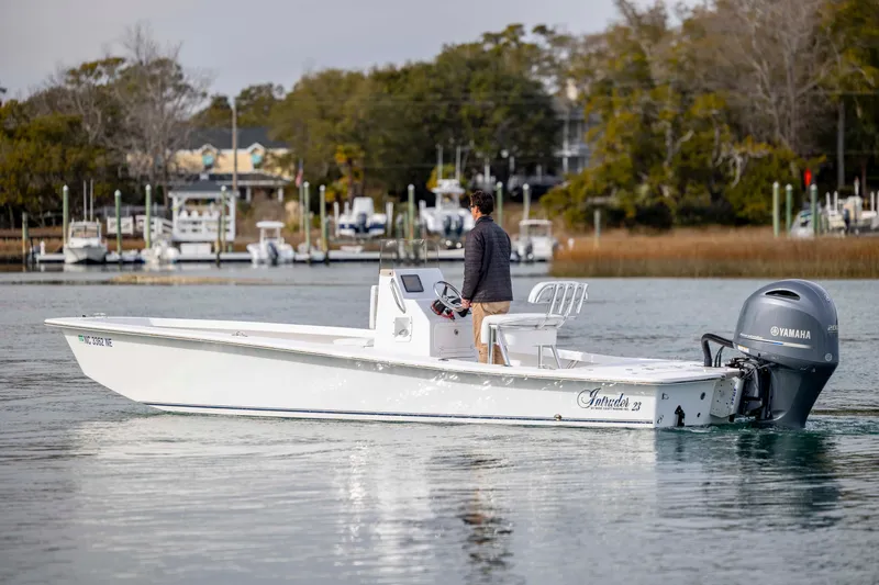 Slide: The Image of Man steering 2025 Intruder 23 boat with Yamaha engine on calm water. - 6